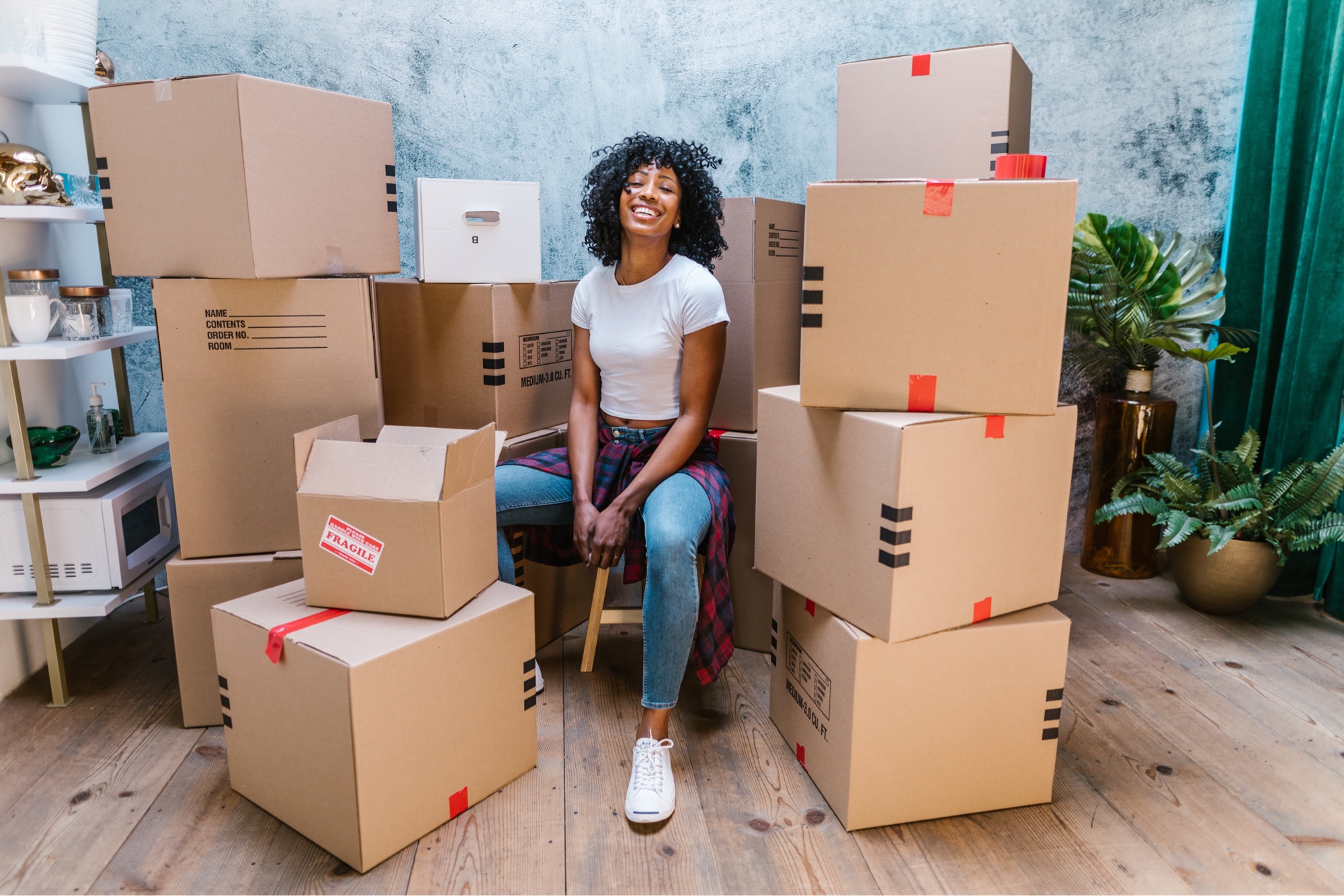 Happy woman surrounded by moving boxes